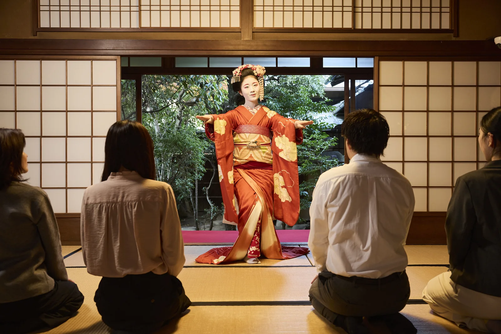 A maiko performing a traditional dance for guests in Gion